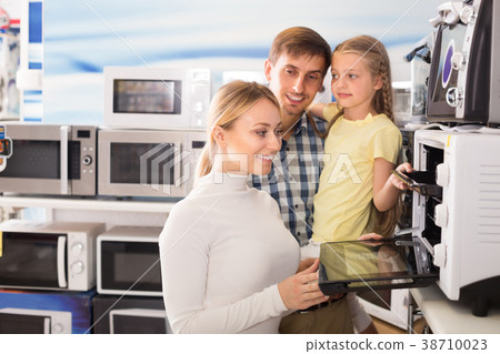 Portrait of positive family choosing microwave 38710023