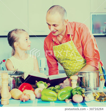 Man with little daughter at kitchen. 38710264