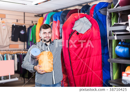 Happy customer examining touristic equipment Happy customer examining touristic equipment 38710425
