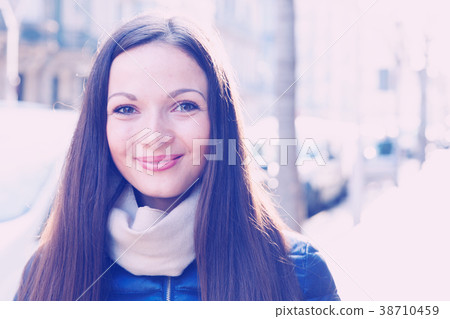 Glad female in the jacket walking at the street Glad female in the jacket walking at the street 38710459