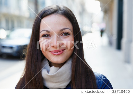 Portrait of young smiling woman in jacket in the city 38710460