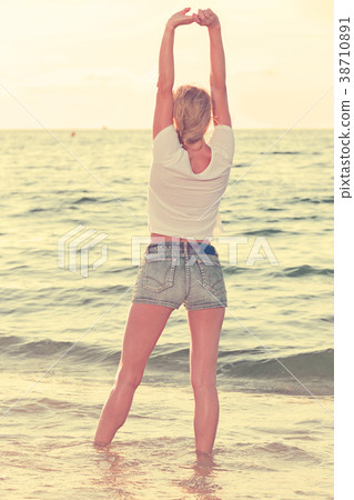 Smiling woman 25-35 years old is standing on the beach 38710891