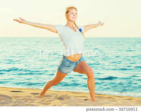 Smiling adult woman in white T-shirt is doing excercises on endurance Smiling adult woman in white T-shirt is doing excercises on endurance 38710911