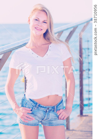 Cheerful female is posing playfully on pirce in her free time Cheerful female is posing playfully on pirce in her free time 38710956