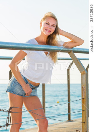 Elegant woman is posing on pirce in her free time Elegant woman is posing on pirce in her free time 38710986