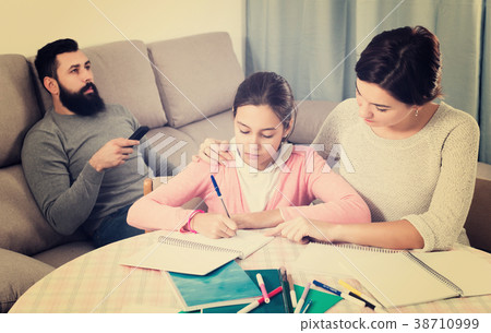 Mother helping child to do homework 38710999