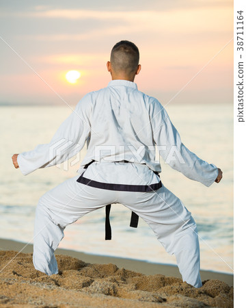 Joyful male doing karate at ocean quay 38711164