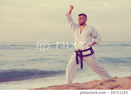 Man is exercising to doing the Kokutsu-dachi stance Man is exercising to doing the Kokutsu-dachi stance 38711183