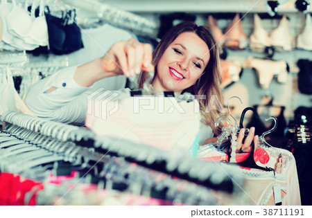 Woman client choosing brassiere in underwear store Woman client choosing brassiere in underwear store 38711191