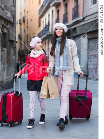 tourists girl and woman walking with baggage tourists girl and woman walking with baggage 38711253