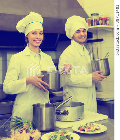 Two cooks at restaurant kitchen Two cooks at restaurant kitchen 38711483