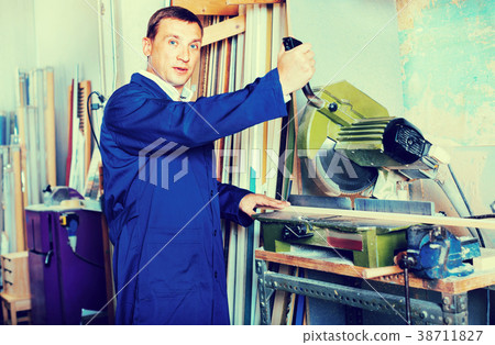 Man operating circular saw in wood workshop 38711827