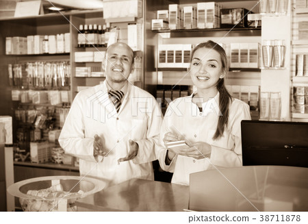 Positive professional pharmaceutists at reception Positive professional pharmaceutists at reception 38711878