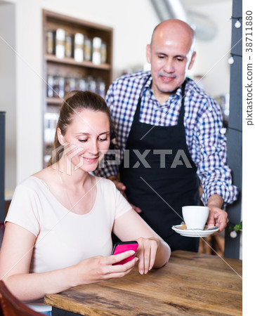 Young waiter brought coffee to a girl Young waiter brought coffee to a girl 38711880