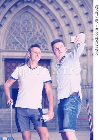 Two men with luggage doing selfie Two men with luggage doing selfie 38712028