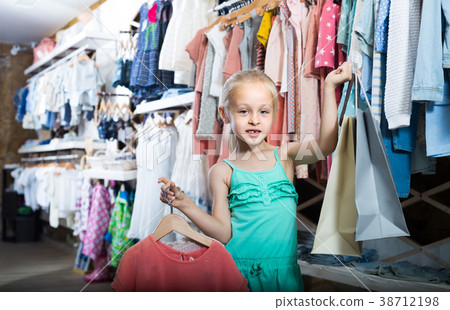 portrait of girl standing in kids clothes store with shopping bags portrait of girl standing in kids clothes store with shopping bags 38712198