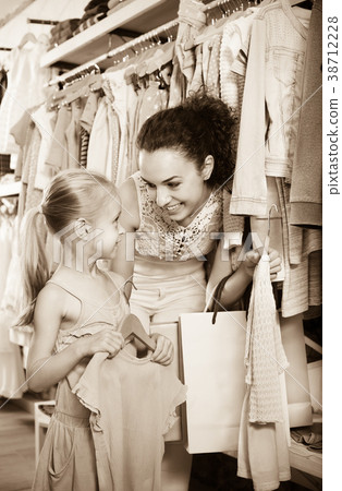 Woman with small girl choosing pink clothes Woman with small girl choosing pink clothes 38712228