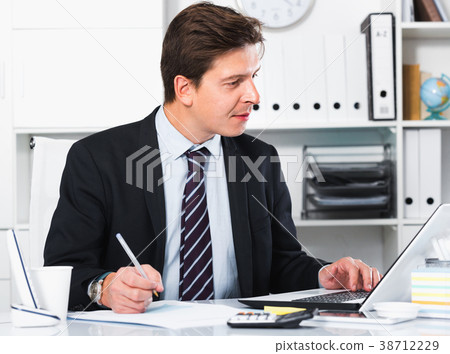 Businessman in office clothes filling up documents Businessman in office clothes filling up documents 38712229