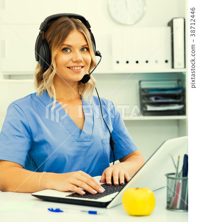 Attentive specialist of medical call center in headphones in off Attentive specialist of medical call center in headphones in off 38712446