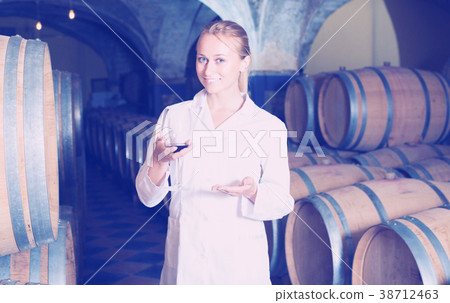 Woman checking ageing process of wine Woman checking ageing process of wine 38712463