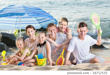 Parents children under sun umbrella 38712535