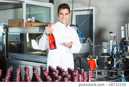 happy man employee standing in final section of wine production on factory happy man employee standing in final section of wine production on factory 38712538