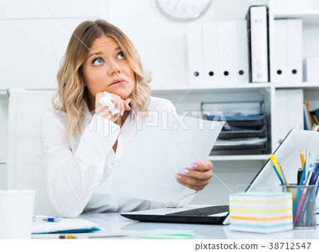 Thoughtful young girl in corporate-type clothes in well-lit office Thoughtful young girl in corporate-type clothes in well-lit office 38712547