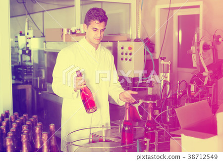 Glad man holding newly produced bottle of wine Glad man holding newly produced bottle of wine 38712549