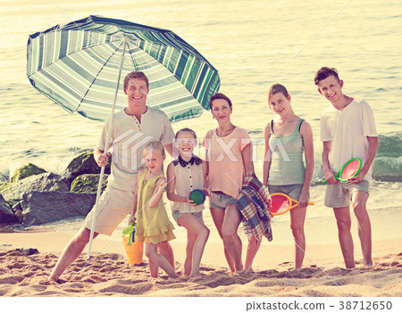 Large smiling family standing together on beach on summer day Large smiling family standing together on beach on summer day 38712650