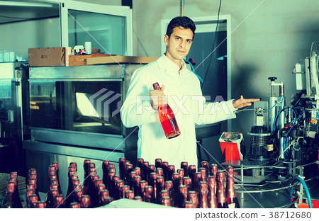 man employee standing in final section of wine production on factory man employee standing in final section of wine production on factory 38712680