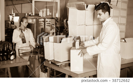 Man standing in packing section on winemaking factory Man standing in packing section on winemaking factory 38712682