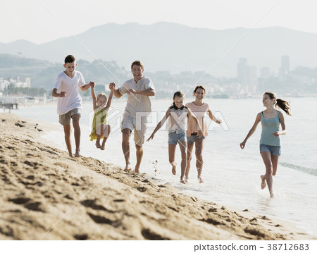 Big family running on beach 38712683