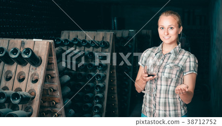 woman holding glass of wine in cellar. woman holding glass of wine in cellar. 38712752