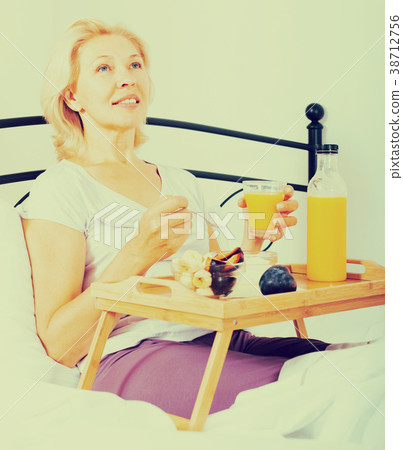Elderly woman enjoying healthy breakfast Elderly woman enjoying healthy breakfast 38712756
