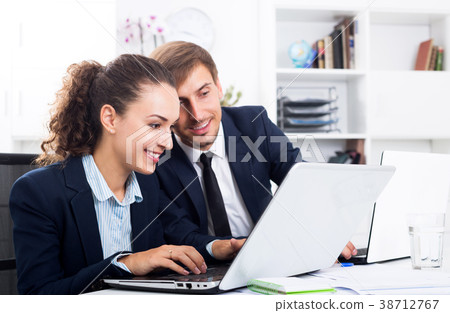 Two office workers work using laptops 38712767