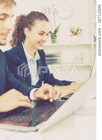 Glad business female assistant wearing formalwear using laptop Glad business female assistant wearing formalwear using laptop 38712898
