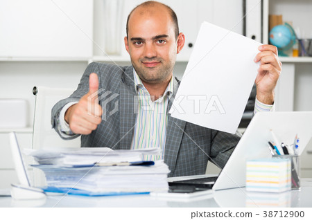 Businessman in shirt viewing documents at the table 38712900