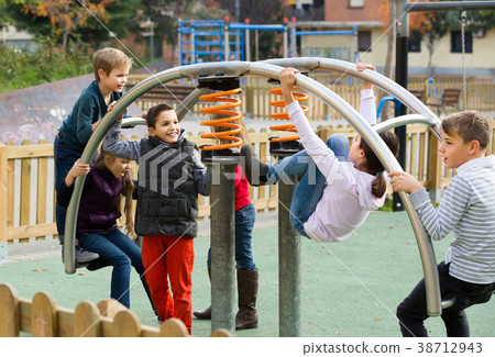 glad girl with long hair in school age sitting on swing on children's playground outdoors glad girl with long hair in school age sitting on swing on children's playground outdoors 38712943