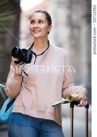 Smiling female is leafing through the booklet 38712962