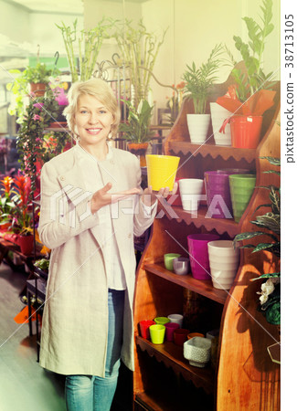 Smiling retiree female customer choosing flower pot Smiling retiree female customer choosing flower pot 38713105