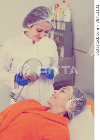 Woman client checking result of beauty procedures 38713132