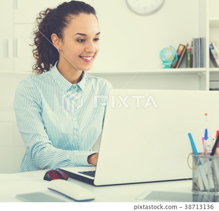 Business lady sitting at office desk with laptop Business lady sitting at office desk with laptop 38713136