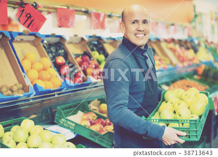 Elderly seller offering seasonal ripe fruits in local grocery Elderly seller offering seasonal ripe fruits in local grocery 38713643