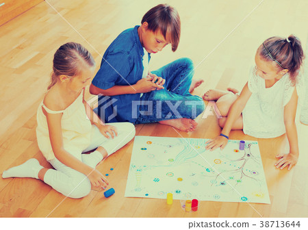 Children playing board game. 38713644