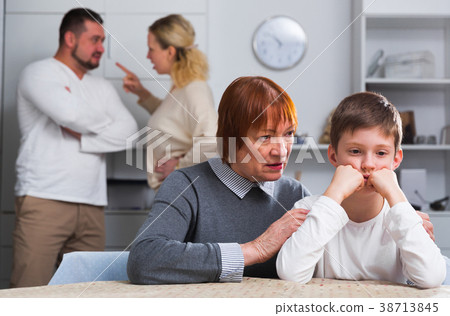 Woman calming boy during parents quarrel Woman calming boy during parents quarrel 38713845