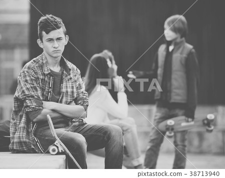 Upset boy and couple of teens apart on the street 38713940
