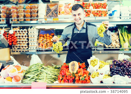 Young male seller is displaying assortment Young male seller is displaying assortment 38714095