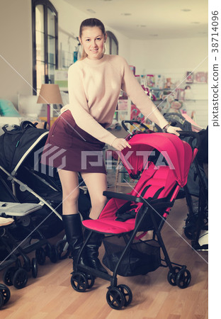 Smiling mother buyer choosing stroller cane Smiling mother buyer choosing stroller cane 38714096