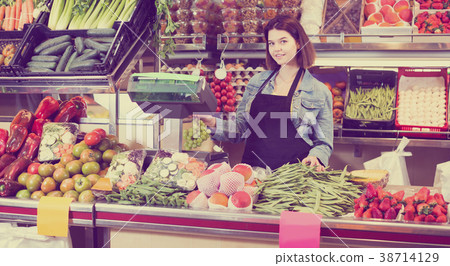 shopping assistant weighing fruit and vegetables in grocery shop shopping assistant weighing fruit and vegetables in grocery shop 38714129