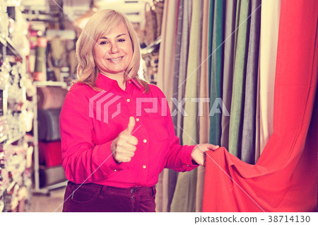 Female seller demonstrating curtain and showing thumb up 38714130